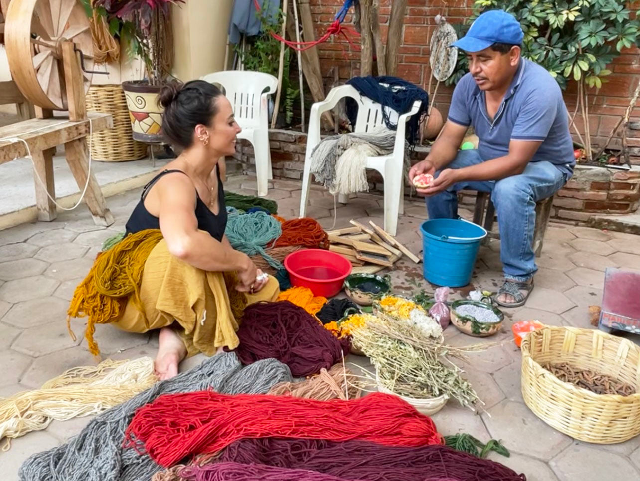 Moana Dixon of HUNTEDFOX sitting on the ground among colorful dyed wool