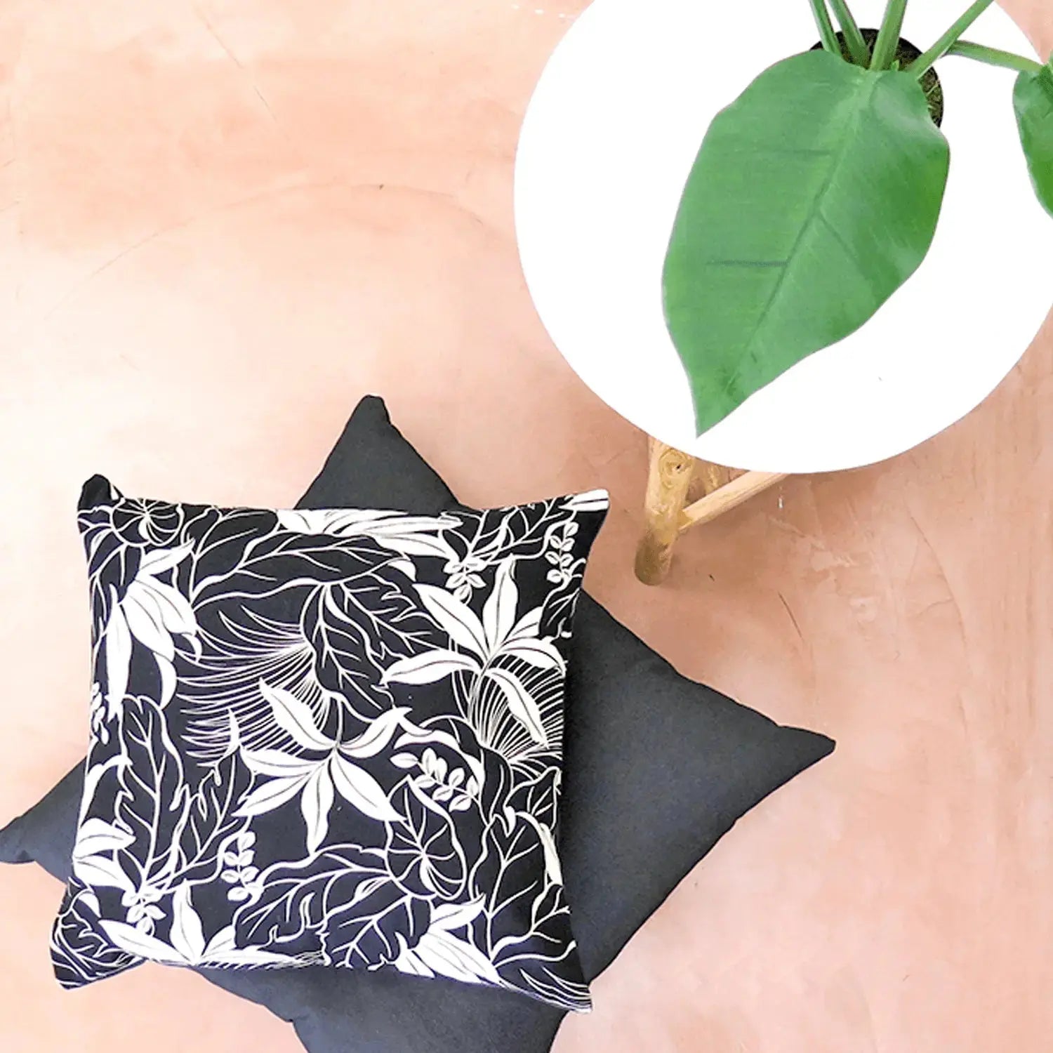 Modern black-and-white tropical throw pillow with bold botanical print