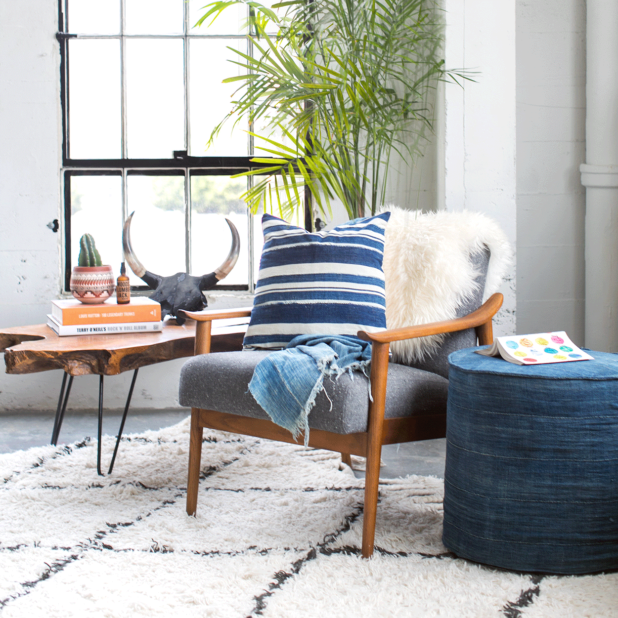 Blue & White Striped Pillow sitting on a grey chair in a modern loft
