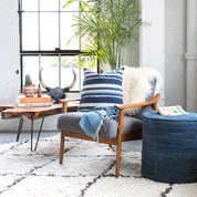 Blue & White Striped Pillow sitting on a grey chair in a modern loft