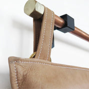 Tan leather strap on wall mount close up