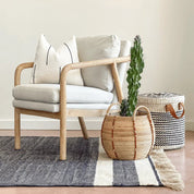 white-handwoven-pillow-black-accents sitting on chair