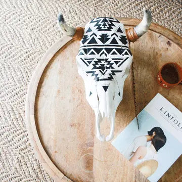 black and white cow skull sitting on top of a table next to a Kinfolk Magazine