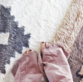 woman's feet standing on top of vintage shag rugs