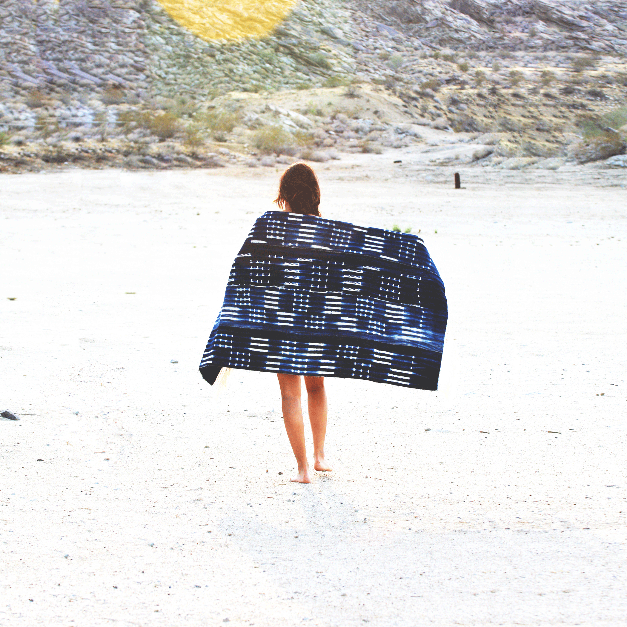 girl walking in the desert with vintage denim blanket and fur lining