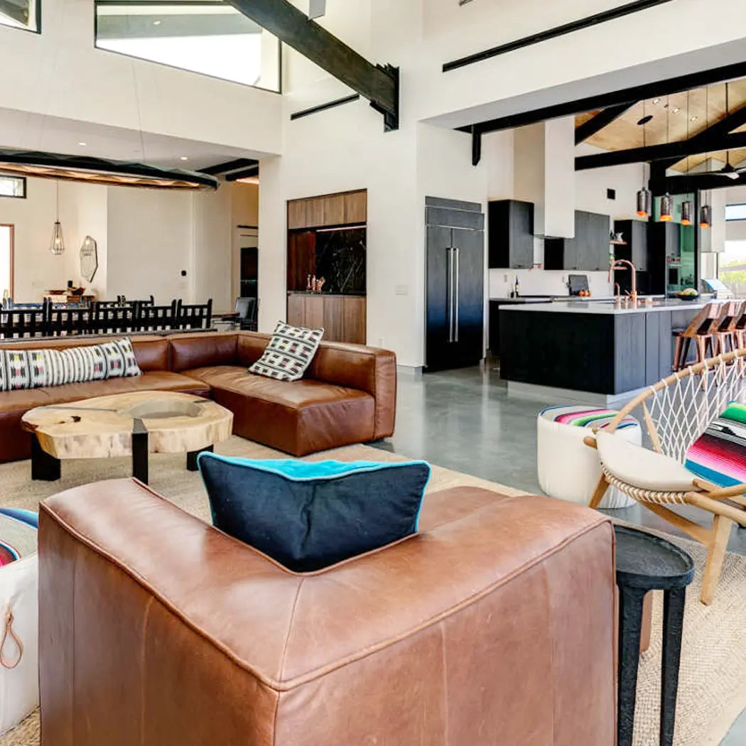 modern hacienda living room setting with custom colorful decor next to leather sofa and large cieliings