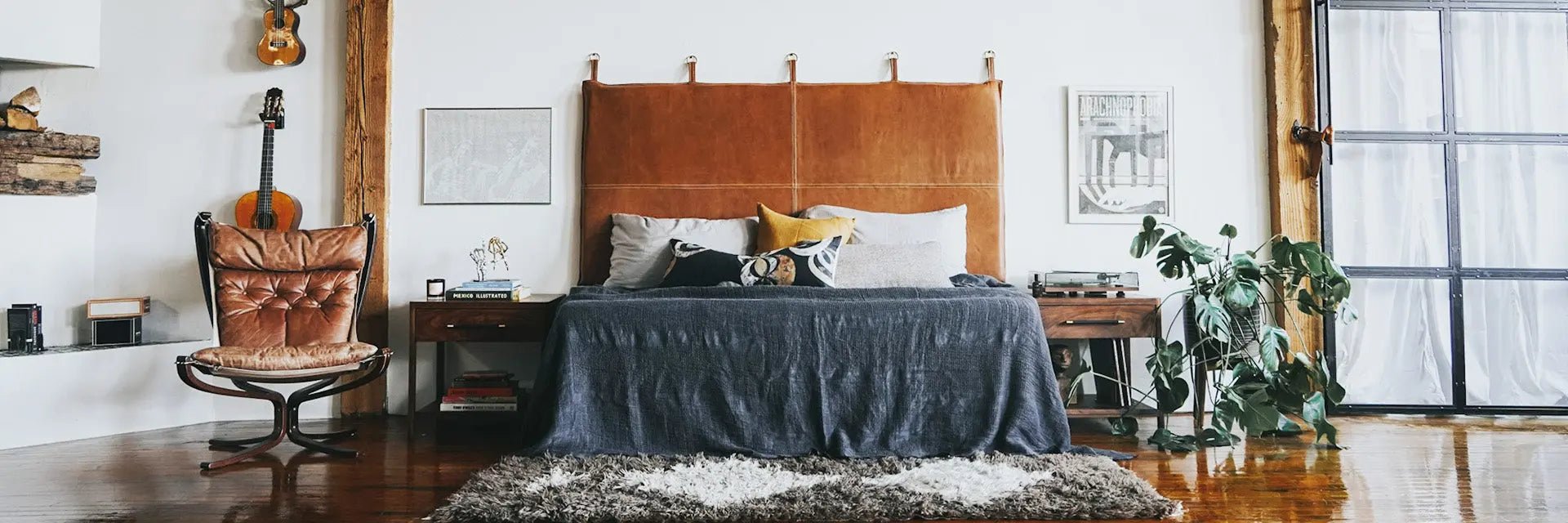 leather hanging wall mount headboard in a loft next to a large glass door and fireplace