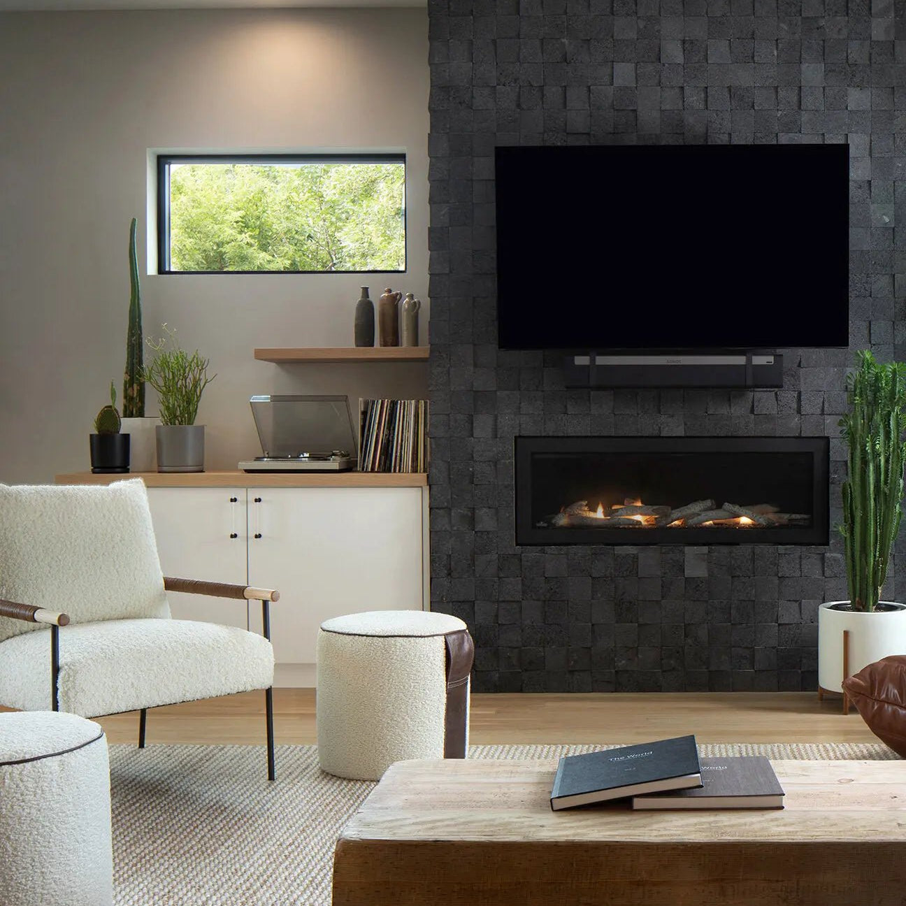 sophisticated living room setting with shearling and leather ottoman next to stone fireplace