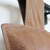 Aged Tan Leather Wall - Mount Headboard - headboardLEATHERShopify CollectiveHUNTEDFOX - close - up of tan leather headboard with brass mounting strap