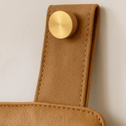 Aged Tan Leather Wall - Mount Headboard - headboardLEATHERShopify CollectiveHUNTEDFOX - close - up of tan leather headboard with brass mounting strap
