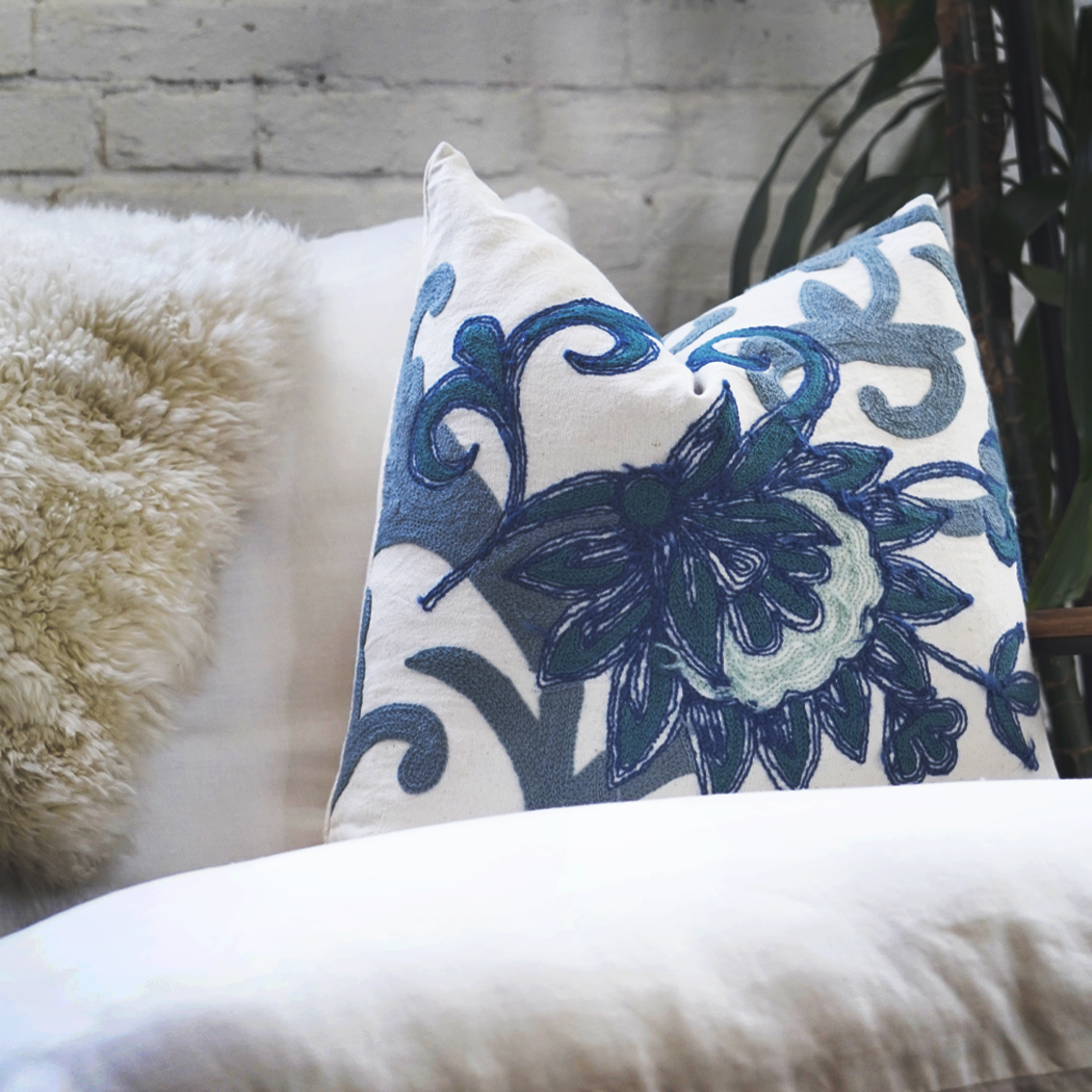 blue-and-white-floral-pillow-on-white-chair.png