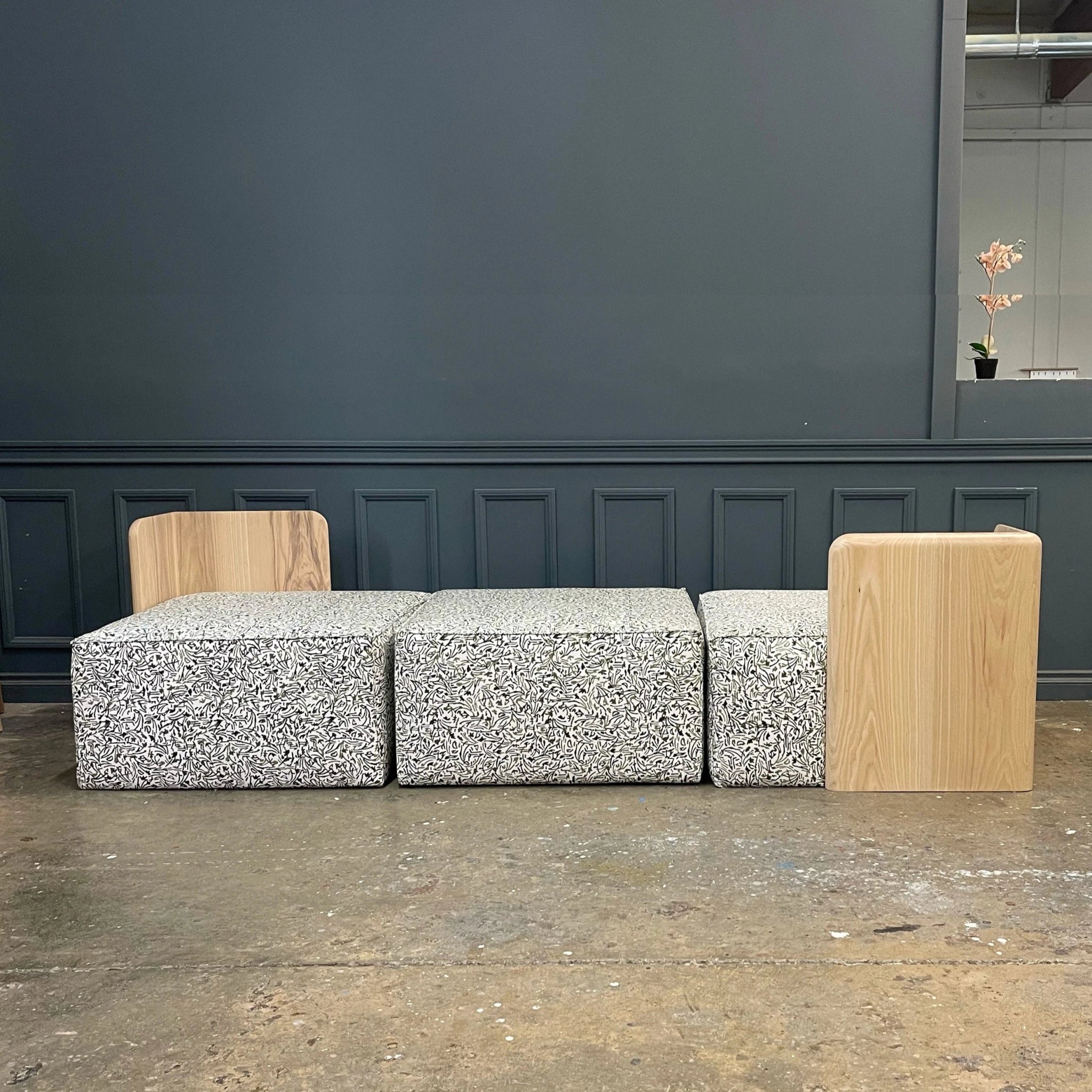 Modular Sectional Universal Seating Set - CUSTOMfurnitureH|F AtelierHUNTEDFOX - Custom modular sofa with a contemporary design, featuring patterned upholstered cushions and natural wood backrests, handcrafted for a modern living space.