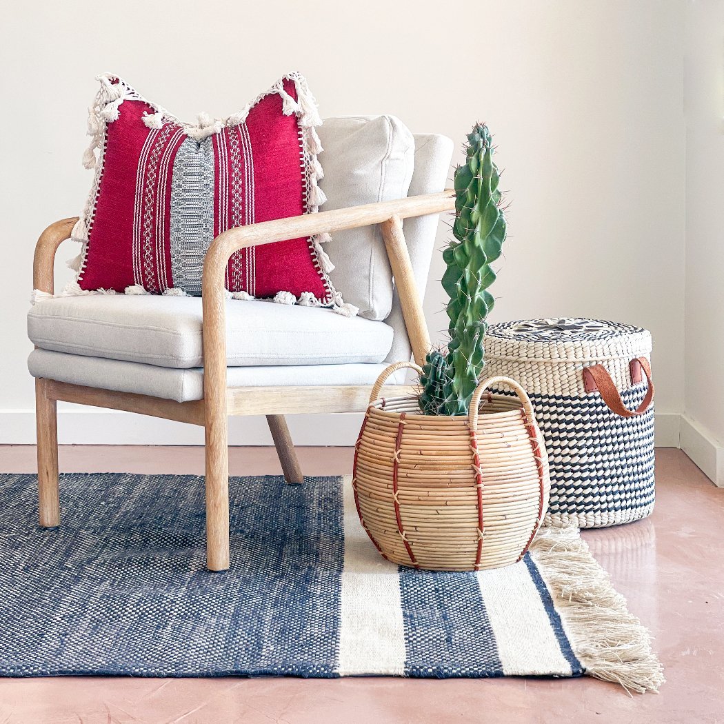 Red and White Boho Throw Pillow With Fringe - BAJA CHICNEWorangeHUNTEDFOX - Red and white striped pillow sitting on a chair next to a cactus